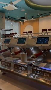 Three coffee machines with digital displays and cup.