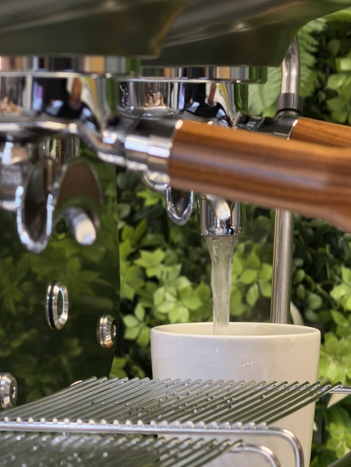 Water pouring into a white coffee cup