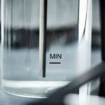 Close-up of a glass measuring beaker with MIN marked.
