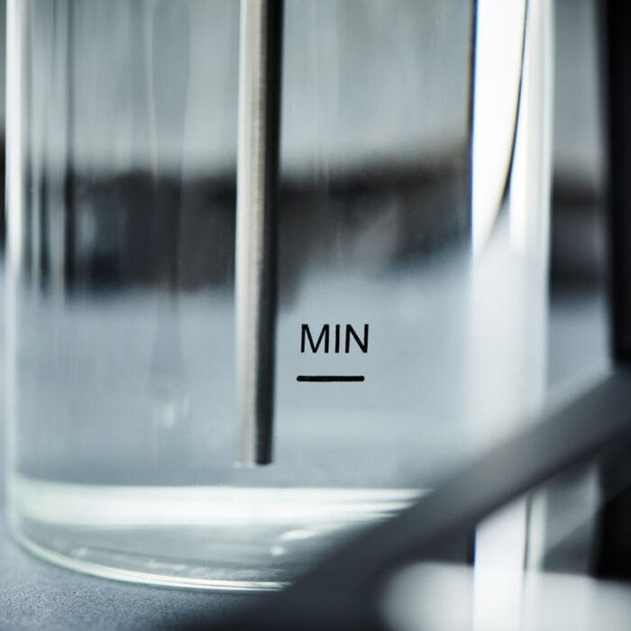 Close-up of a glass measuring beaker with MIN marked.