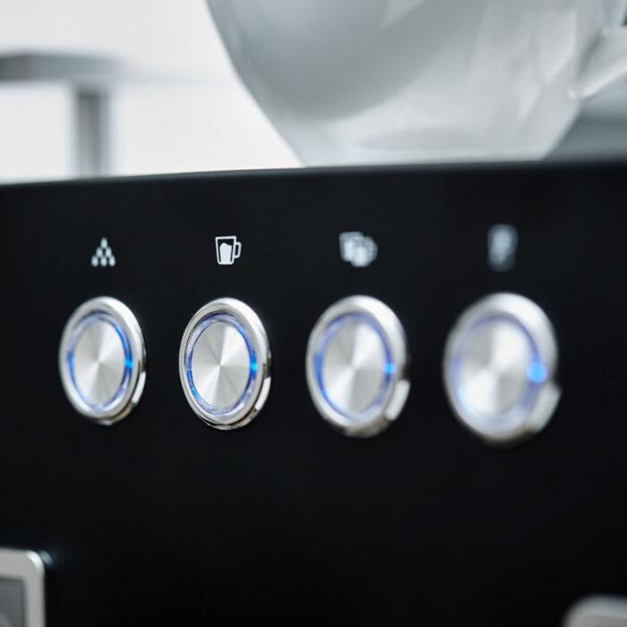 Close-up of coffee machine control knobs.