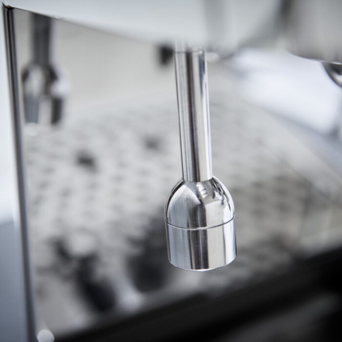 Close-up of a stainless steel coffee machine component.