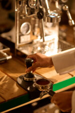 Barista preparing espresso on a coffee machine.