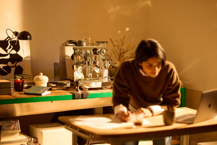 Person working at a table with coffee and laptop.