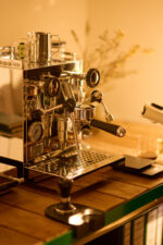 Shiny espresso machine on a wooden table.