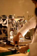 Barista preparing coffee with an espresso machine.