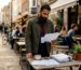 Man reviewing coffee supplier documents in café office