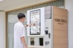 Person using Flying Turtle specialty vending machine.