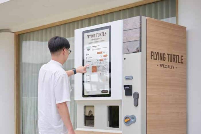 Person using Flying Turtle specialty vending machine.