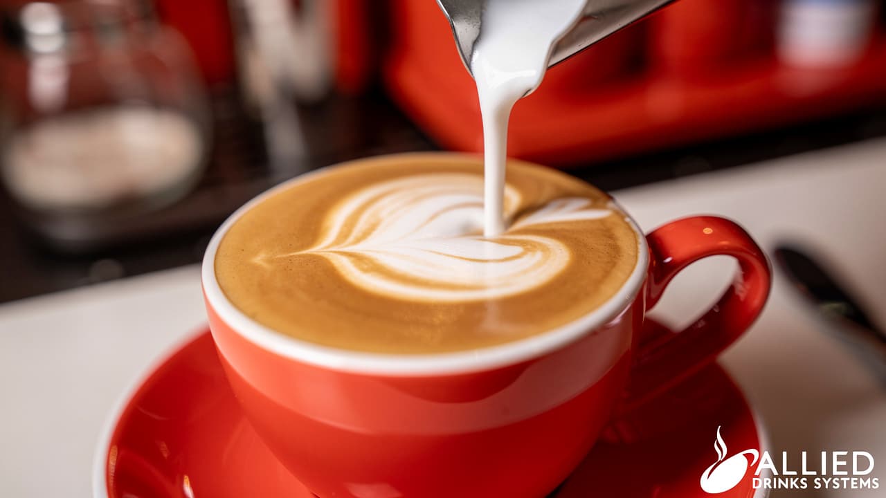 Skilled barista pouring steamed milk to create latte art