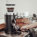 Mahlkönig E65S coffee grinder in use on a coffee bar