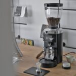 Mahlkönig E65S GbW coffee grinder in use on a coffee bar
