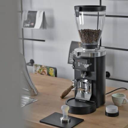 Mahlkönig E65S GbW coffee grinder in use on a coffee bar